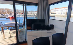 A room with a television, a desk, and a chair. - Hausboot in Boltenhagen (Boltenhagen)