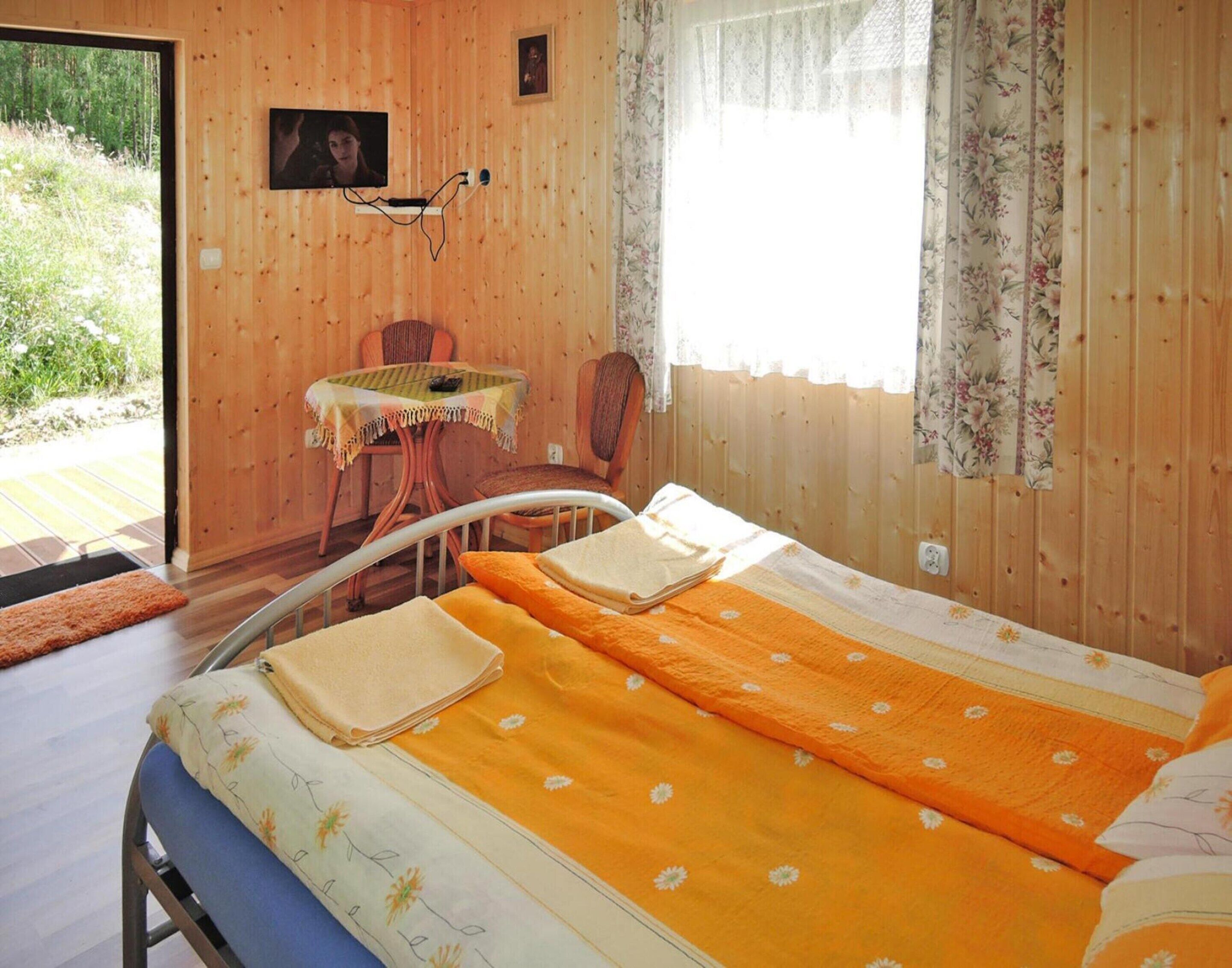 Una stanza accogliente con un letto, un tavolino e una sedia.