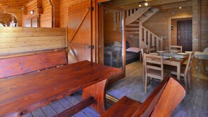 Un interno in legno con zona pranzo, una panca e una scala.