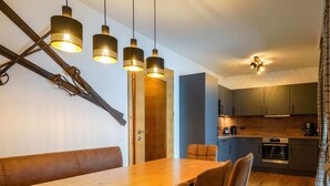 A modern kitchen with dark cabinets, a wooden countertop, and a built-in oven. - Kitzbuhel Alpine Lodge With Private Infrared Sauna (Mittersill)