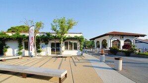 A building with a tiled roof, a bench, and a flag. - Bungalow in Caorle With Garden Furniture (Caorle)