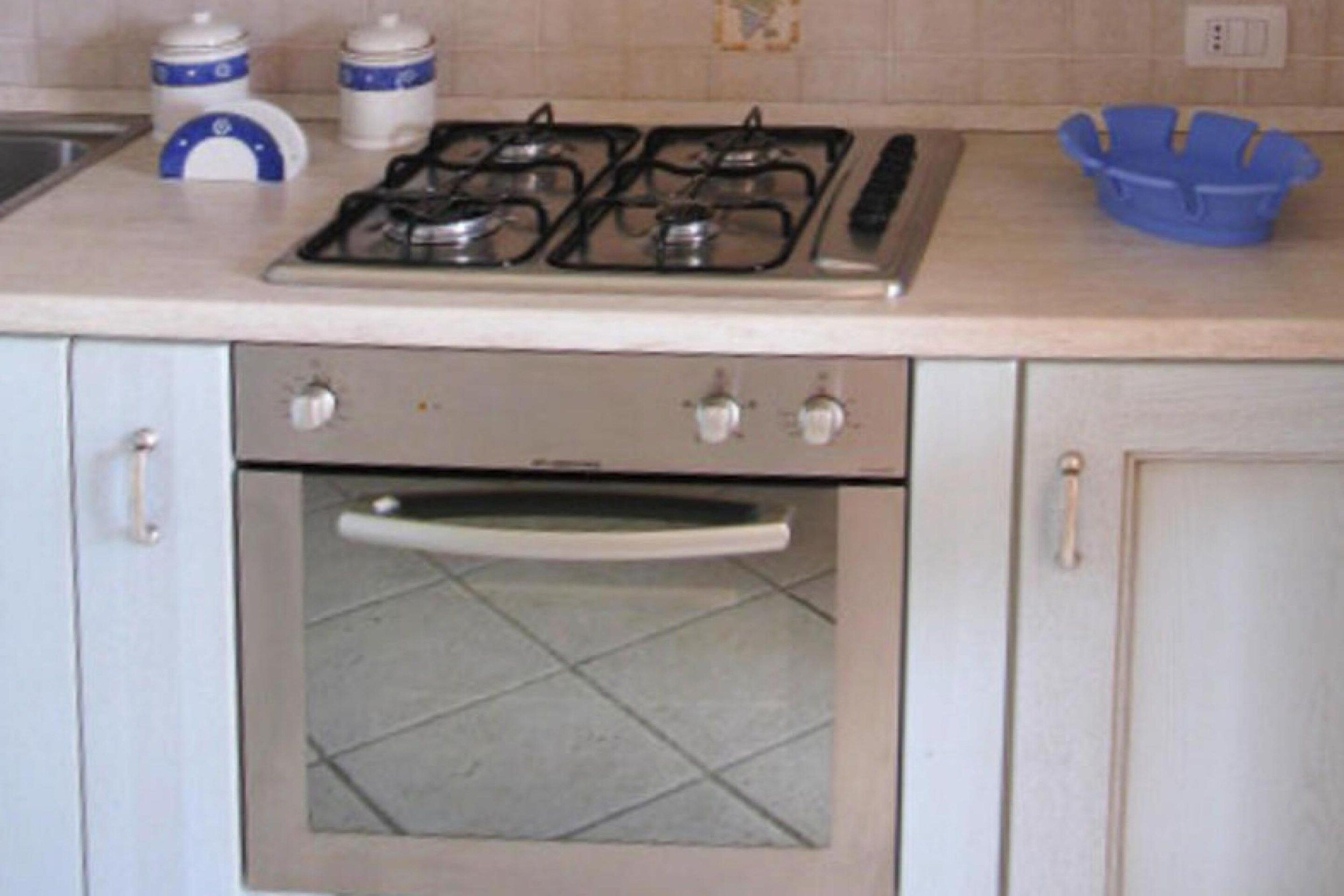 A kitchen with a gas stove, oven, and cabinets.