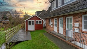 A two-story house with a red exterior and a brick facade. - Ferienwohnung in St. Peter-ording (St. Peter-Ording)