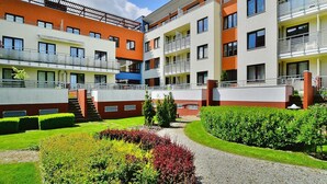 A multi-story residential building with balconies, a central courtyard, and well-maintained gardens. - Apartment, Kolobrzeg (Kolobrzeg)