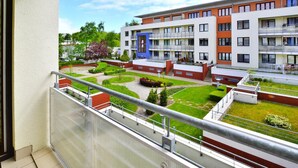 A modern apartment building with multiple balconies, a well-maintained courtyard, and a clear view of the surrounding greenery. - Apartment, Kolobrzeg (Kolobrzeg)