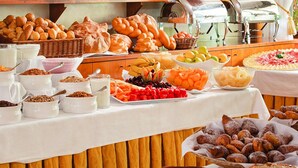 A buffet table with various food items including pastries, fruits, and desserts. - Apartments Poiano in Garda (Garda)