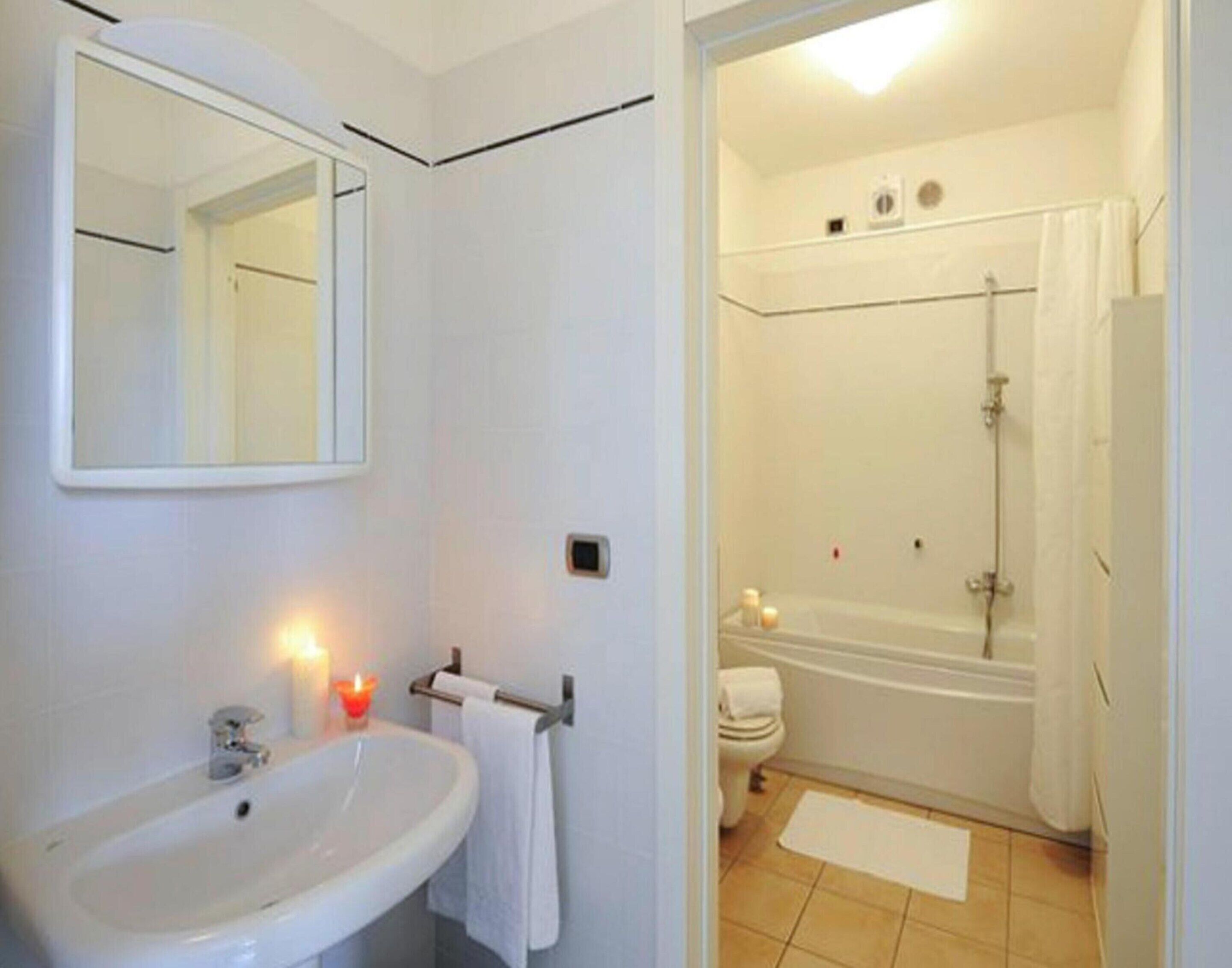 Une salle de bain équipée d’un lavabo, d’un miroir et d’un espace douche.