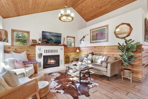 Un salon chaleureux avec une cheminée, des meubles en bois et un tapis en peau de vache.