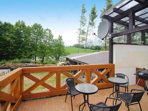 A patio with outdoor seating, a barbecue grill, and a satellite dish.