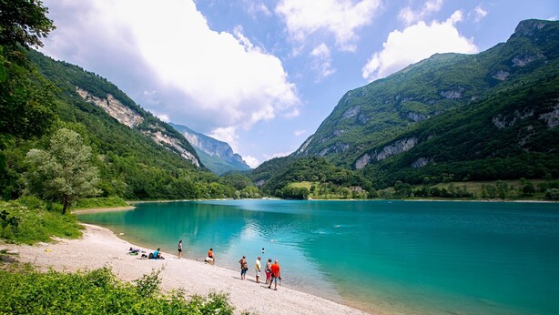 A lake surrounded by mountains with a group of people on the shore. - Il Giardino In Montagna Child Friendly (Tenno)