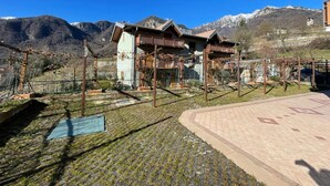 A chalet-style building with a wooden balcony, surrounded by a mountainous landscape. - Il Giardino In Montagna Child Friendly (Tenno)