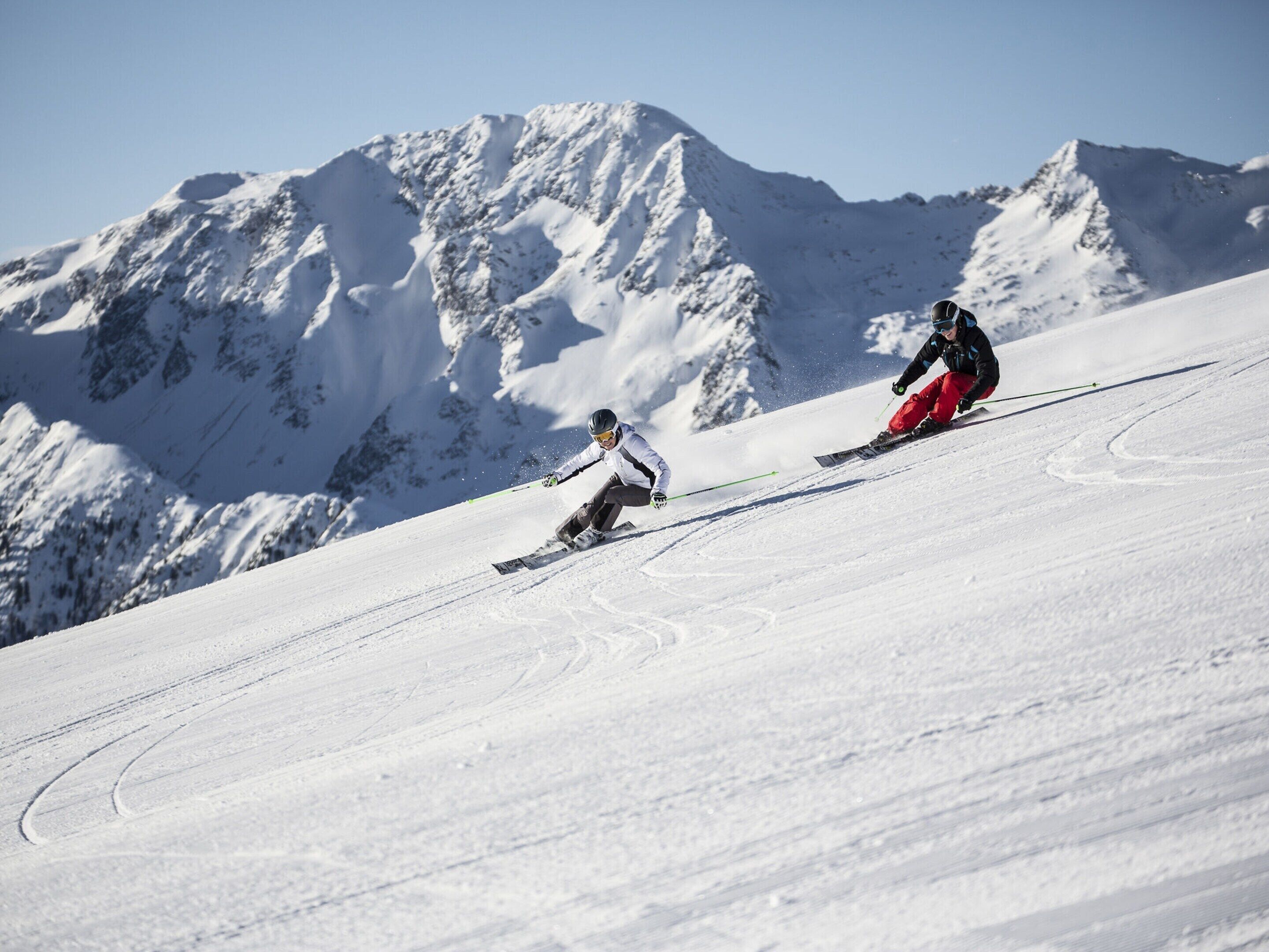 Ein verschneiter Berghang mit Skifahrern.