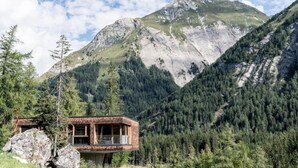 A mountain cabin with a balcony overlooking a forested valley. - Chalet Resort Near Lake (Kals am Grossglockner)