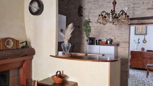 Een landelijke keuken met zichtbare bakstenen muren, een houten bar en een hanglamp.