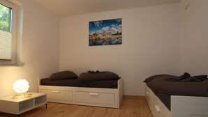 A bedroom with a bed, a bedside table, and a wall-mounted picture. - Ferienhaus am Rande der Lewitz (Lüblow)