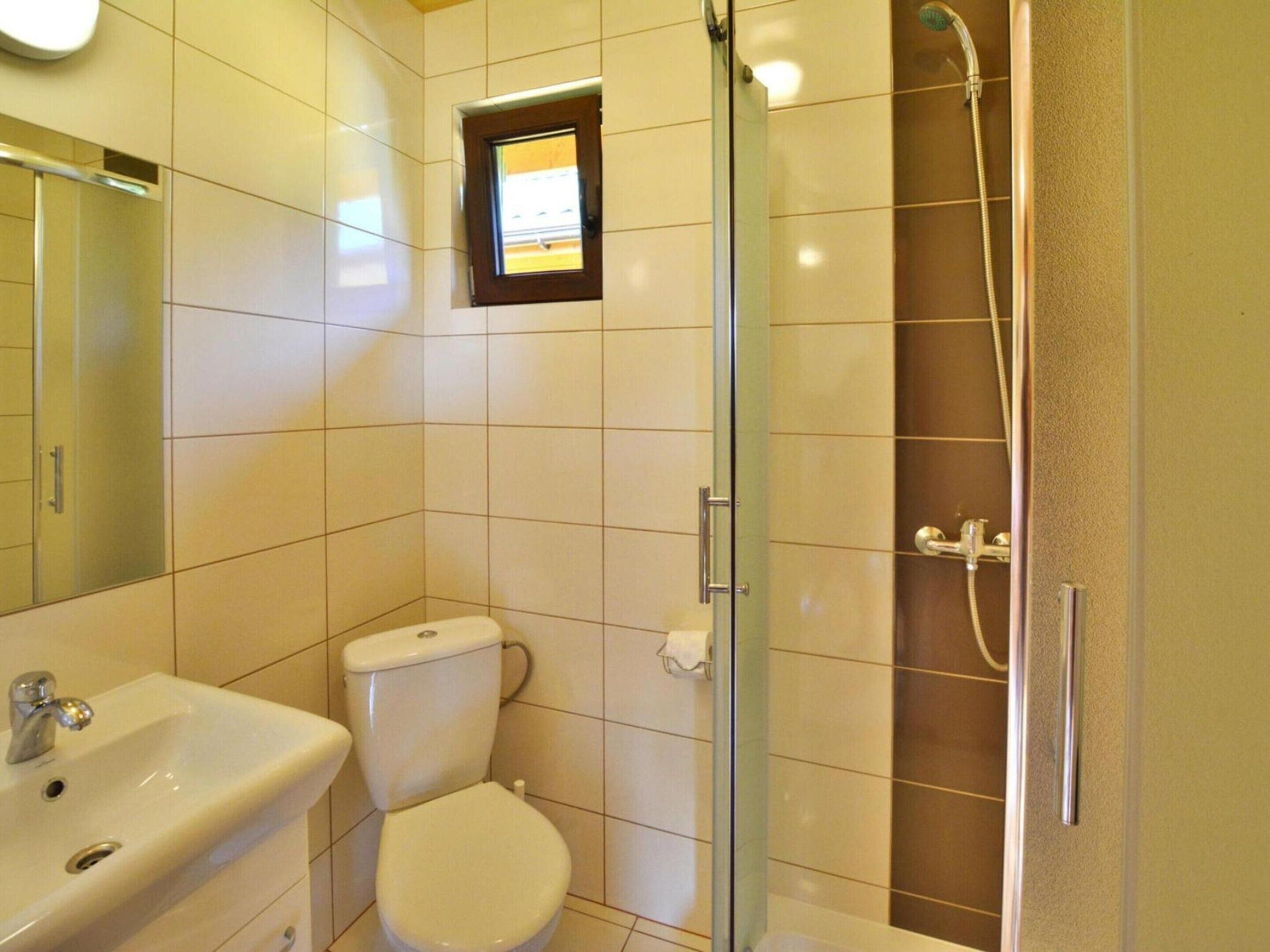 A bathroom with a toilet, sink, and shower.