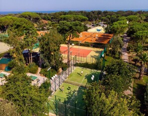 An aerial view of a tennis court surrounded by lush greenery and trees. - Bungalow in San Vincenzo With Shared Pool (San Vincenzo)