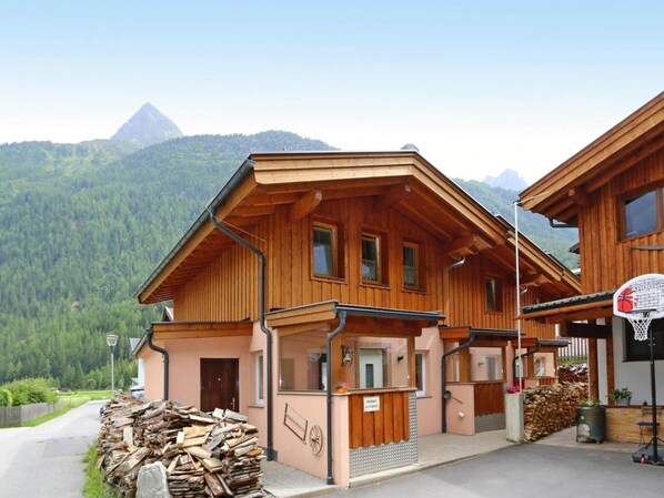 A wooden chalet with a balcony, a basketball hoop, and a mountain backdrop. - Terraced Houses Oliver, Langenfeld (Laengenfeld)