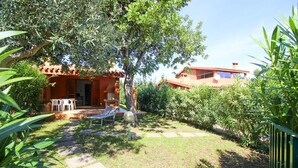 Una villa con patio, mobili da esterno e un giardino.