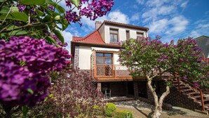 A two-story house with a red-tiled roof, a balcony with a wrought-iron railing, and a brick exterior. - Holiday Home Near Baltic Sea & Swinoujscie (Swinoujscie)