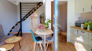 Eine moderne Küche mit Mikrowelle, Schränken und einer Glastür zum Essbereich mit Tisch und Stühlen.