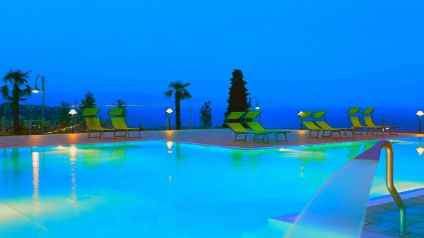 A swimming pool with lounge chairs and palm trees in the background. - Residence Villa Beuca, Cogoleto (Cogoleto)