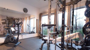 A gym with exercise equipment, large windows, and a mirror. - Holiday Home With Sauna and Jacuzzi (Damp)