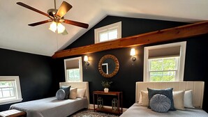 A bedroom with two beds, a ceiling fan, a rug, and a small table with a plant. - Spacious 7 bedroom house, Near jiminy Peak  in Hancock ma , In the Berkshires (New Lebanon)