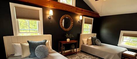 A bedroom with two beds, a ceiling fan, and a large rug.