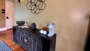 A modern living room with a black console table, a hexagonal wall art piece, a coffee maker, and a decorative bowl. - Spacious 7 bedroom house, Near jiminy Peak  in Hancock ma , In the Berkshires (New Lebanon)