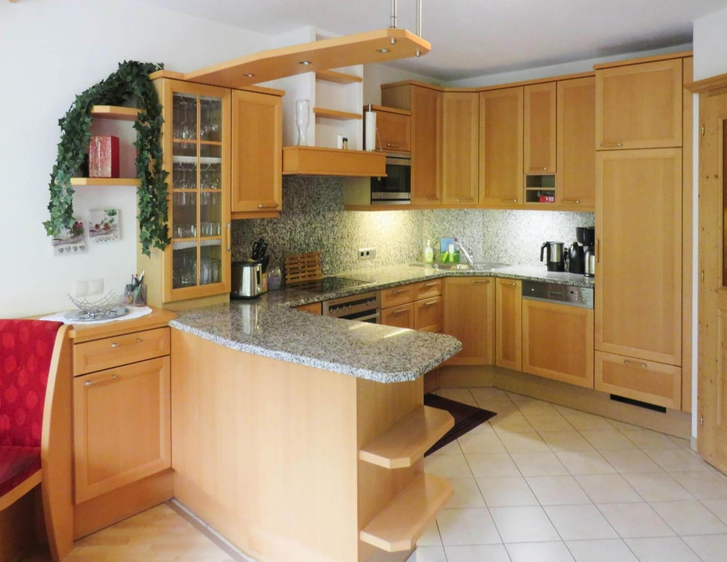 A kitchen with wooden cabinets, granite countertops, and a built-in island.