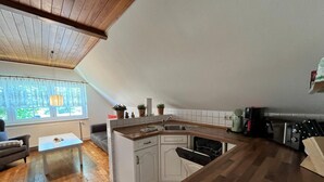 A kitchen with a wooden countertop, white cabinets, and a built-in dishwasher. - Ferienwohnung, Wieck am Darss (Wieck auf dem Darss)