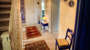 A staircase leading to a hallway with a red patterned rug, a blue chair, and a desk with a lamp. - Holiday Home by Lake Dejgunek Gizycko (Gizycko)