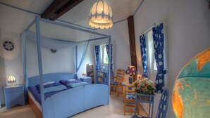 A bedroom with a four-poster bed, a wooden chair, a small table with a lamp, and a globe on the wall. - Holiday Home by Lake Dejgunek Gizycko (Gizycko)