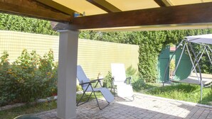 A covered patio area with two lounge chairs and a swing set. - Pretty Holiday Home Casa Luca With Above-ground Pool in Capezzano Pianore (Camaiore)