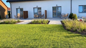 A modern two-story house with a flat roof, large windows, and a well-maintained lawn. - Holiday Home in Grzybowo Near Beach & Bike Path (Kołobrzeg)