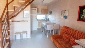 A modern interior with a staircase, a dining area, and a living room with a sofa. - Holiday Homes in Miedzyzdroje for 4 People (Międzyzdroje)