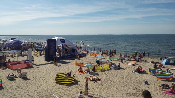 A crowded beach with various tents and beachgoers. - Holiday Homes in Miedzyzdroje for 4 People (Międzyzdroje)