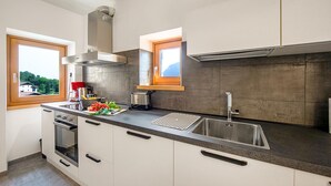 Una cucina moderna con una grande isola, forno integrato e lavello in acciaio inossidabile.