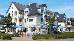 A hotel with outdoor seating, a sign for 'RESIDENCE SEESTERN', and a large ice cream cone sculpture. - Residenz Seestern, Boltenhagen (Boltenhagen)