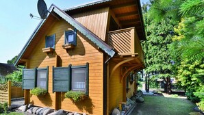 Een houten chalet met schuin dak, een schotelantenne en een klein balkon.