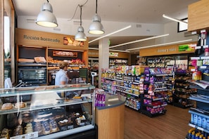 Un rayon boulangerie avec un présentoir de produits de boulangerie et un espace réfrigéré où sont exposés des produits frais.