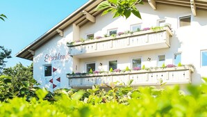 A multi-story building with balconies, a sign reading 'Etschland Pension - Apartment,' and a clear blue sky. - Apartment in Dorf Tirol Near Spronser Lakes (Tirolo)