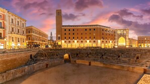 An ancient amphitheater with stone steps and a central stage, surrounded by historic buildings with classical architecture. - Terra Mia In The Historic Center Of Lecce (Lecce)