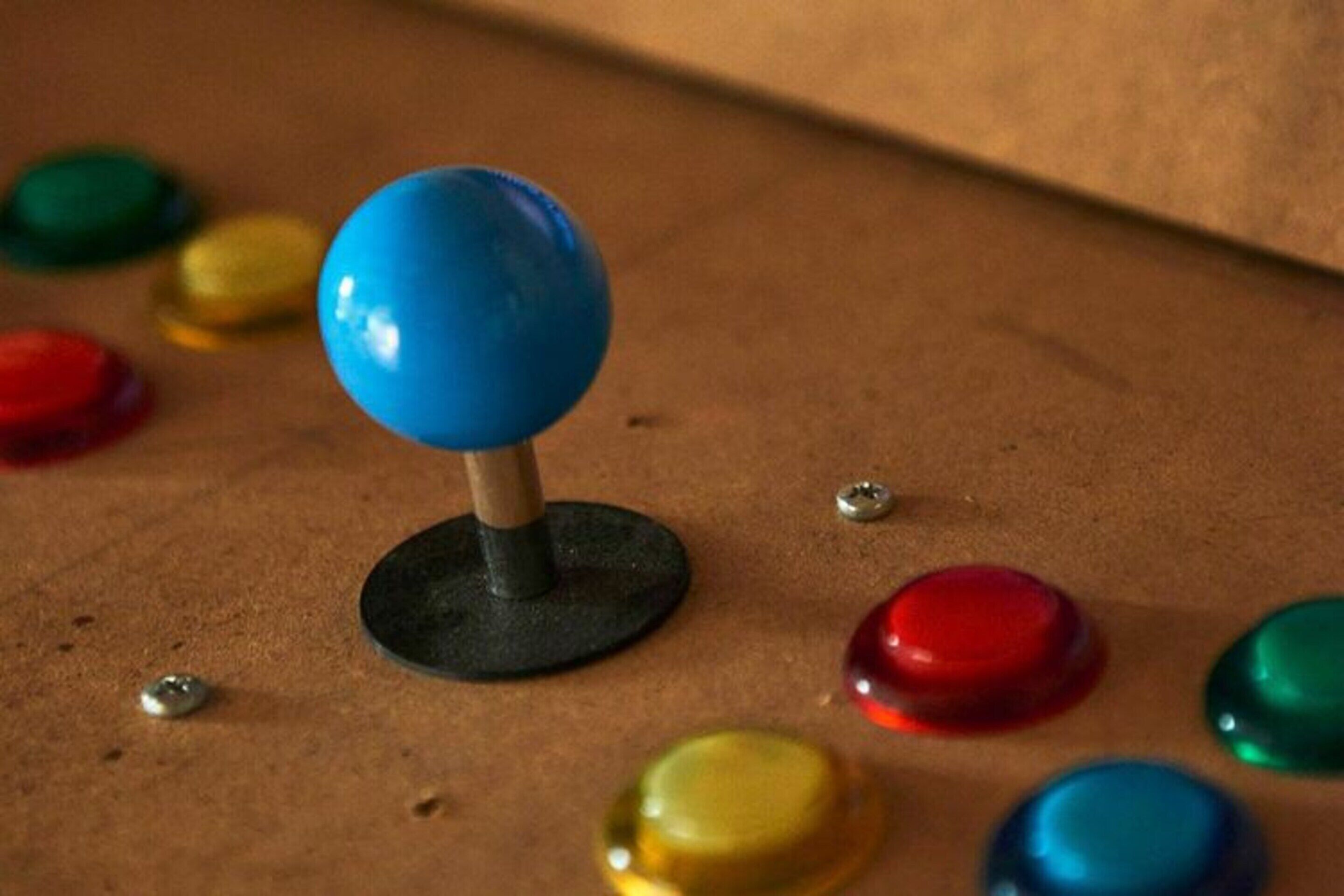 Un joystick con la parte superiore blu su una superficie marrone.