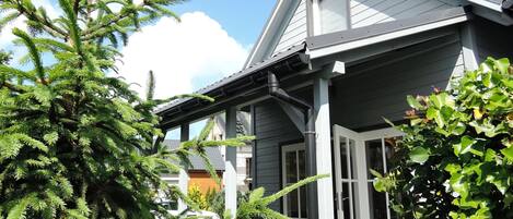A house with a grey roof, white windows, and a porch with a black lamp post.