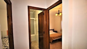 A bedroom with a bed, a nightstand, and a hanging light fixture. - Apartments La Pineda, Playa de Pals (Pals)