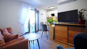 A modern living room with a sofa, a small table, and a TV. - Holiday Home in Mielenko Near Seaside Beach (Mielno)