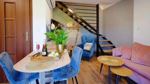 A modern living space with a dining area, a sofa, and a staircase. - Holiday Home in Mielenko Near Seaside Beach (Mielno)