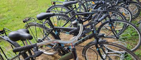 Flere cykler står parkeret udendørs, sandsynligvis i et offentligt område.